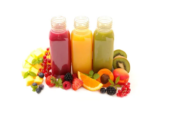 Three colorful juice bottles with fresh fruits on white background