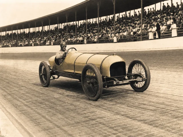 Vintage racing car on a brick track, Indianapolis, circa 1911 — AI-generated editorial illustration