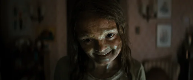 A close-up of a possessed girl in a dark interior from Lee Cronin's The Mummy