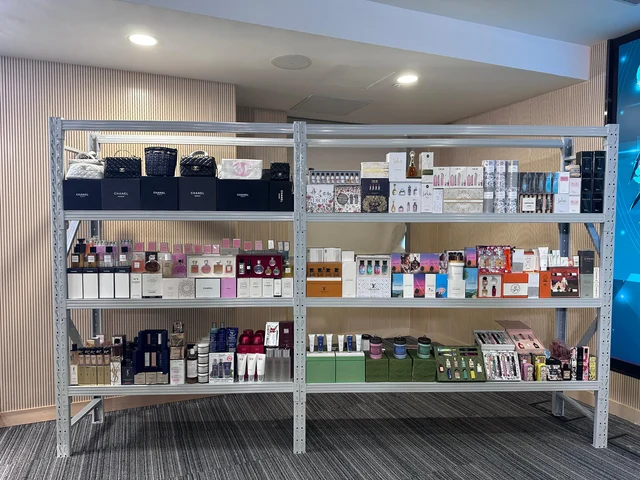 Rows of seized counterfeit perfumes and skincare products on a table, Hong Kong Customs operation, San Po Kong