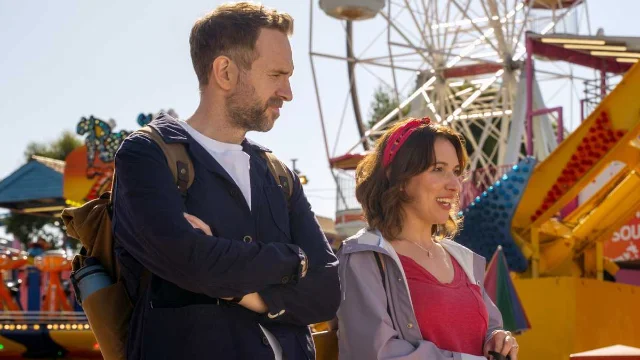 Rafe Spall and Esther Smith standing together at a fairground in Trying Season 5