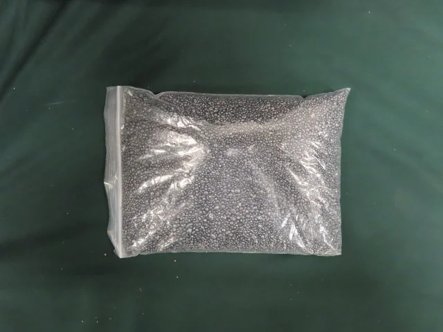 Clear plastic bag packed tight with small dark silver-grey metallic pellets — the seized silver declared as stainless steel structural beads