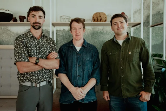 Logan Graham (left, arms crossed), Jack Clark (center), and Keane Lucas (right) — Anthropic Frontier Red Team, photographed for Fortune, September 2025.