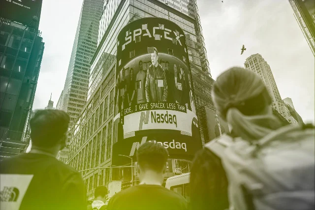 人们仰望写有 SpaceX 的城市广告牌