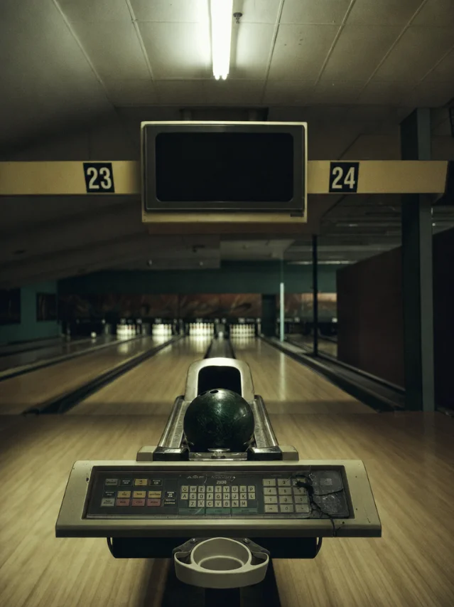 Single bowling ball resting in return track, dead score console overhead
