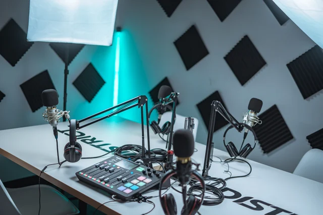 A professional podcast recording studio with multiple microphones and an audio mixer