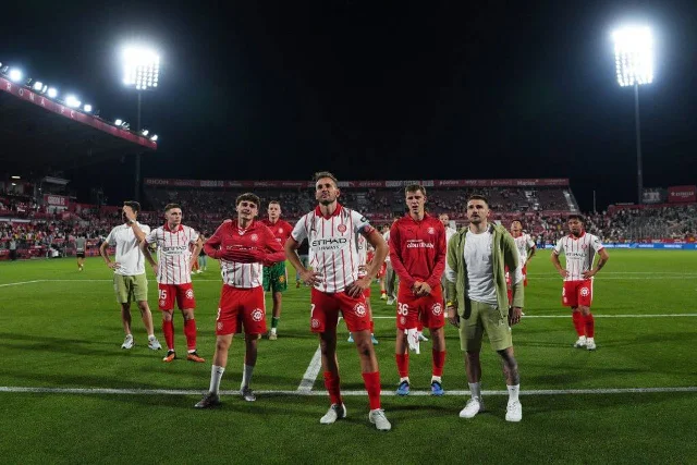 Girona players stand on the Montilivi pitch after the final whistle, La Liga over for them