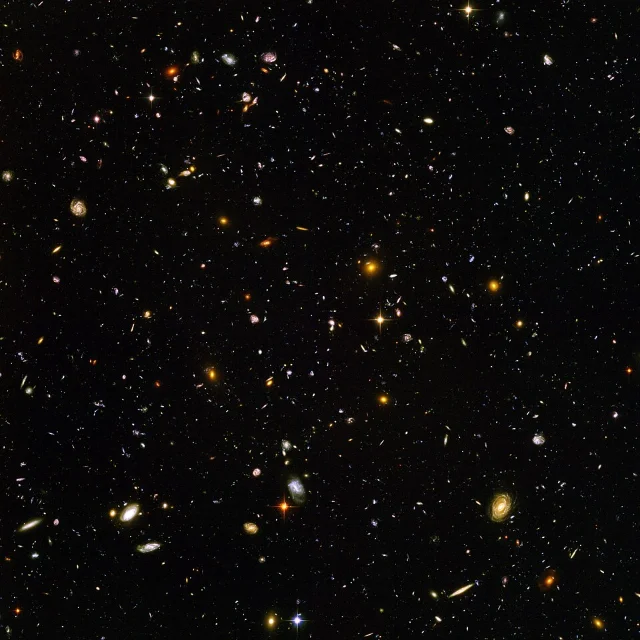 The Hubble Ultra-Deep Field — approximately 10,000 galaxies visible across a sky patch the apparent size of a 1-millimeter object held at arm's length, representing a 1-million-second combined exposure