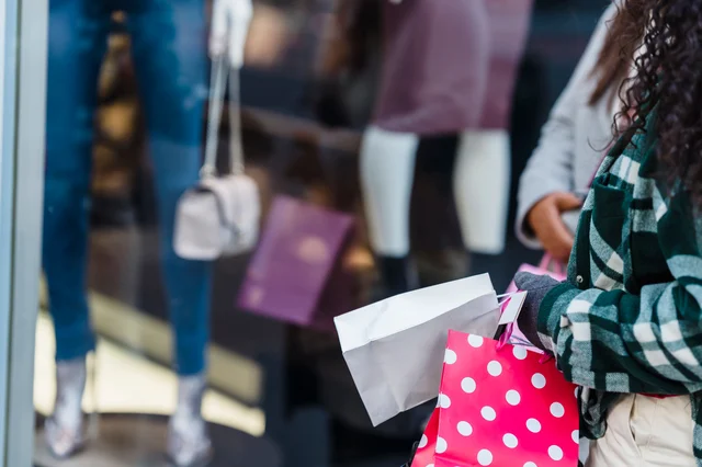 Women with shopping bags standing near counter of a boutique