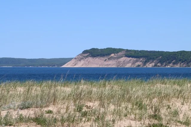 Empire Bluff viewed from Peterson Beach, May 2026 — the bluff rises from Lake Michigan's edge