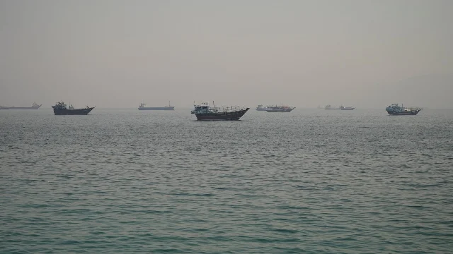 Vessels anchored in hazy waters off the Musandam Peninsula (Oman), looking toward the Strait of Hormuz