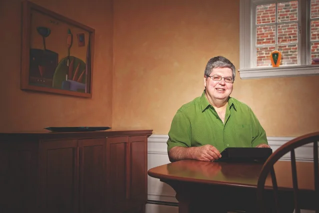 Steve Krug, author of Don't Make Me Think — seated at a wooden desk, smiling at the camera, wearing glasses, orange wall in the background