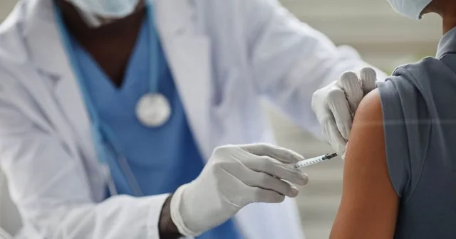 Healthcare provider administering an intramuscular injection to a child's upper arm