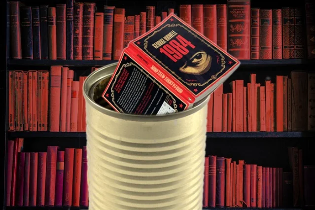 A copy of 1984 being placed inside a metal tin against shelves of red books