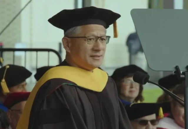 Jensen Huang delivering the keynote at CMU's 128th Commencement, wearing academic regalia at the podium
