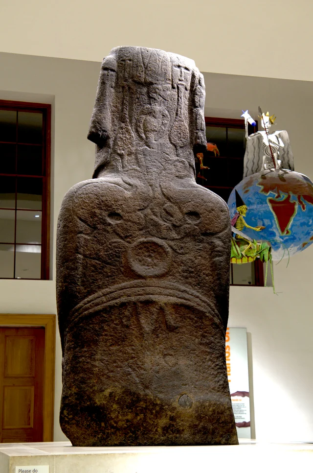 The back of Hoa Hakananai'a showing the maro belt at the lower back, two facing birdman figures above it, the ceremonial paddles on either side, and Y-shaped lines at the top of the head