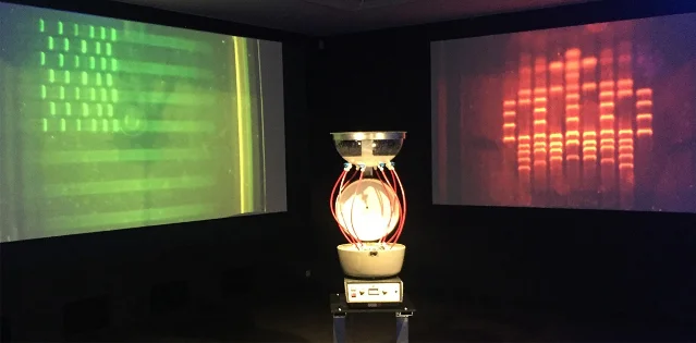 Projected DNA gel images and a tall spittoon in The America Project