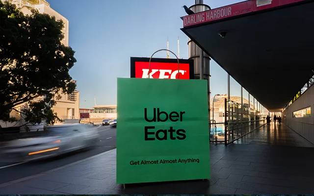 Uber Eats 绿色外卖袋挡住 KFC 户外广告