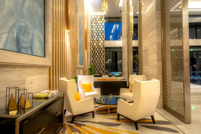 Luxurious hotel lobby with plush armchairs and warm ambient lighting, representing the Hotels.com, Hyatt, and travel Amex Offers expiring June 30