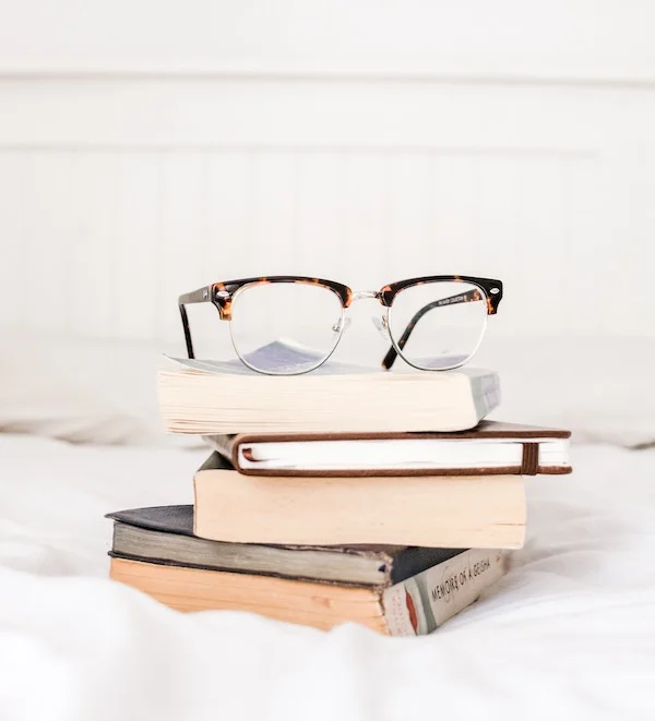 Tortoiseshell glasses on a stack of books