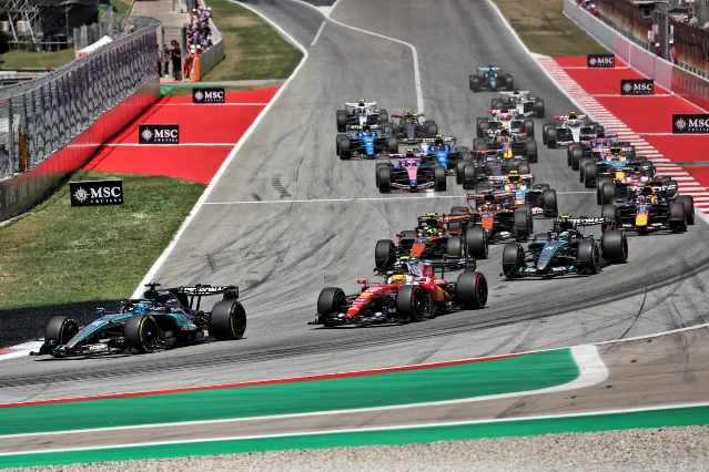 The 2026 F1 grid lines up for the start of the Barcelona-Catalunya Grand Prix, with multiple team liveries visible through a fast corner